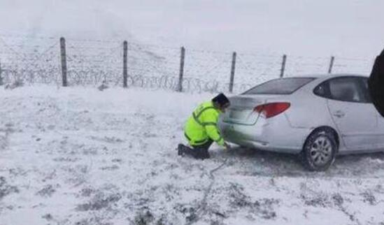 新疆北部多地道路积雪严重 一车辆被困交警清雪救援