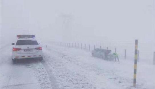 新疆北部多地道路积雪严重 一车辆被困交警清雪救援