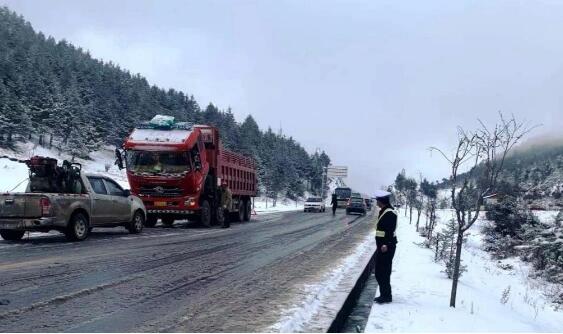 云南迪庆境内多路段出现积雪 交警提醒司机携带防滑链减速通行