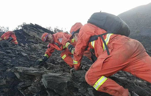 森林消防员在凉山火场近70度陡坡挺进背20公斤的灭火装备爬山
